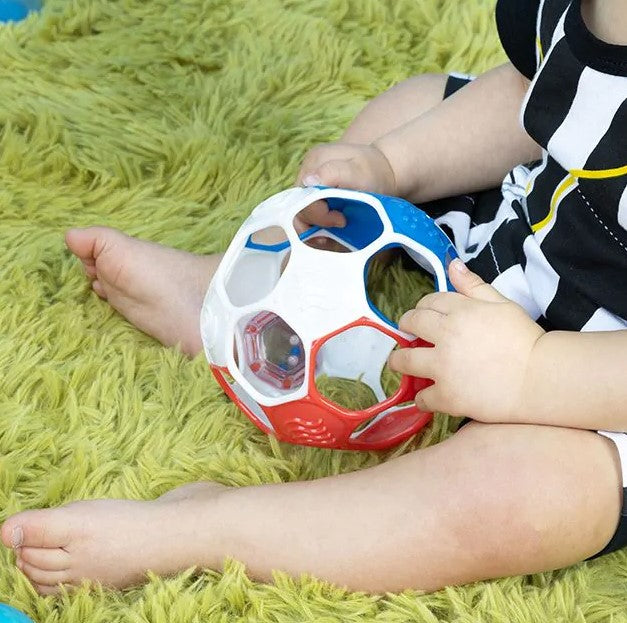 babyhandjes met blauw wit rode voetbal oball